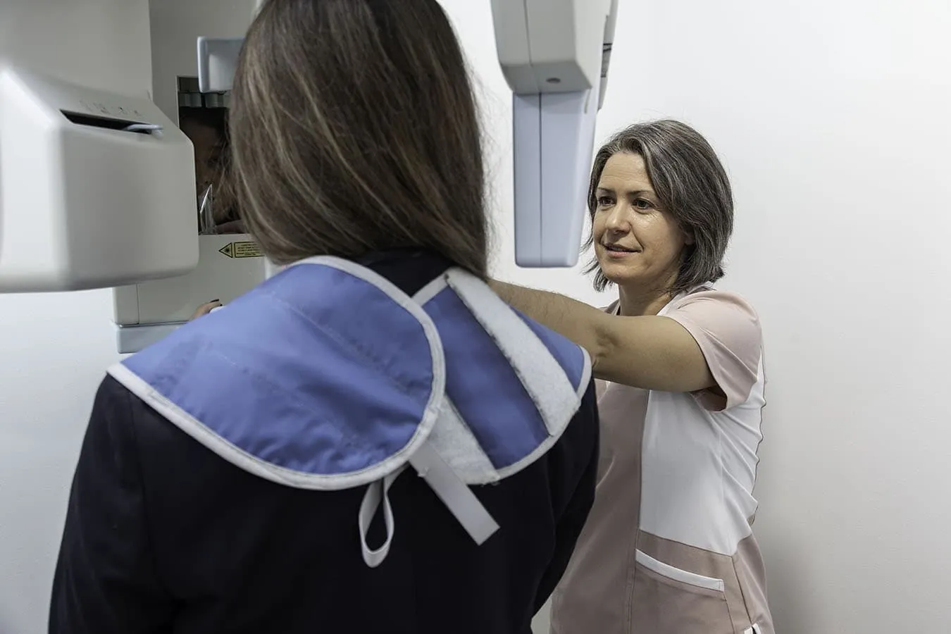 Profesional de la Clínica Dental Paloma Colunga colocando a una paciente en el equipo de radiografía dental